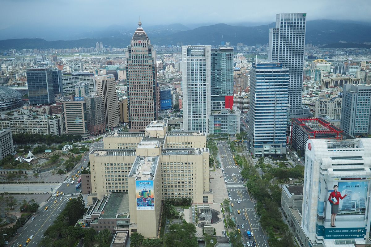 Vista aérea de los rascacielos y las avenidas de Taipéi desde el mirador de Taipei 101, con las montañas al fondo